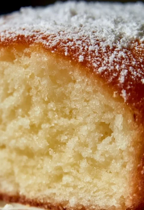 Ciambella yogurt greco super soffice appena sfornata su un piatto.