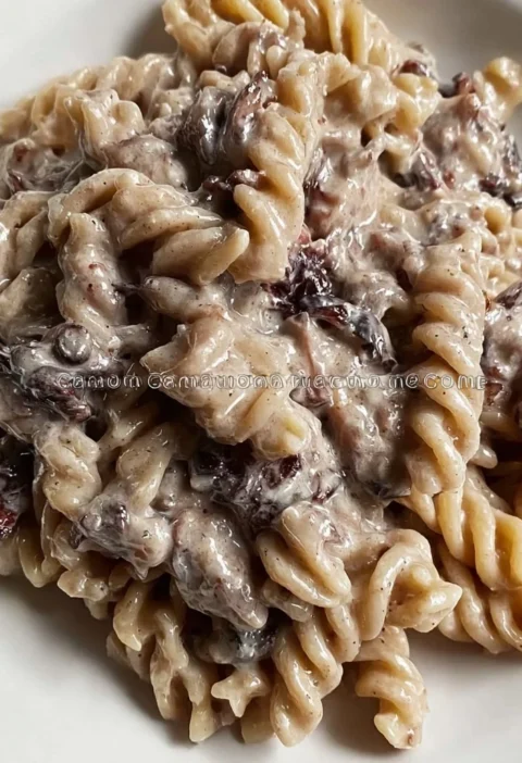 Pasta integrale con crema di radicchio e ricotta servita in un piatto elegante