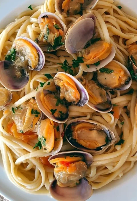 Tagliatelle con vongole, cannolicchi e fasolari in un piatto gustoso.