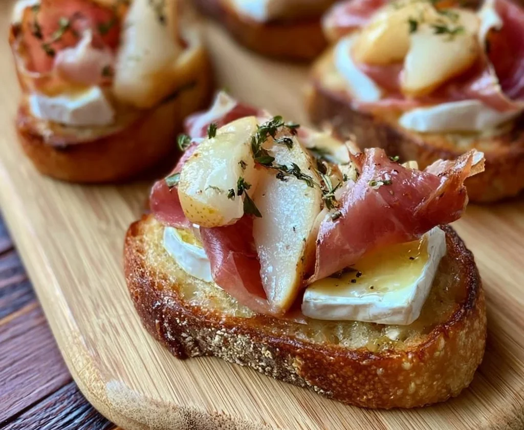 Crostini con brie, pere e prosciutto crudo serviti su un vassoio elegante