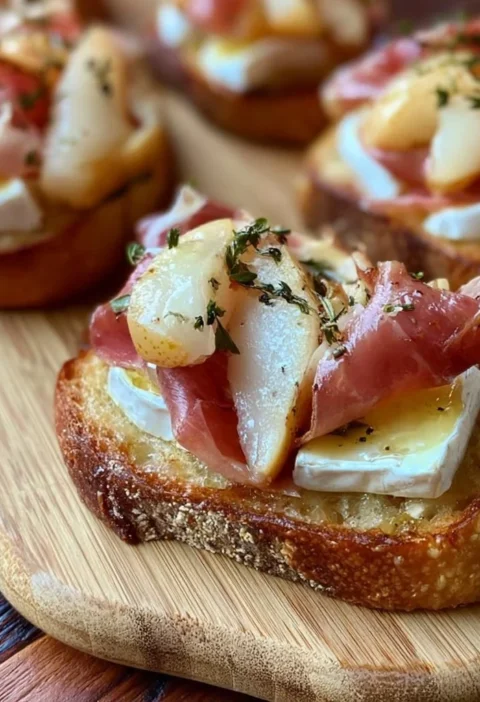 Crostini con brie, pere e prosciutto crudo serviti su un vassoio elegante