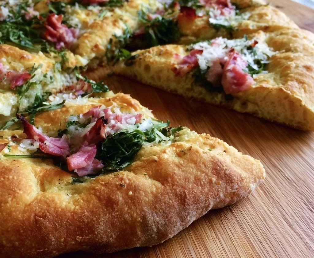 Focaccia furba con rucola e cotto servita su un piatto