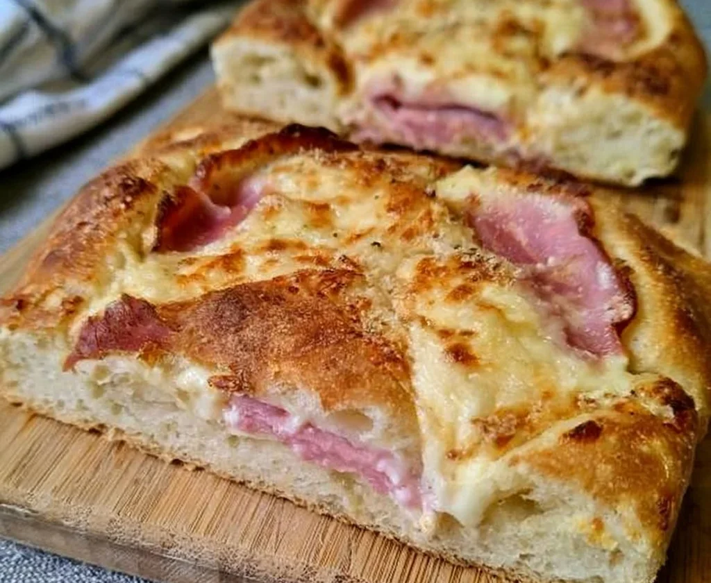 Focaccia soffice con prosciutto cotto e mozzarella, un piatto gustoso e invitante.