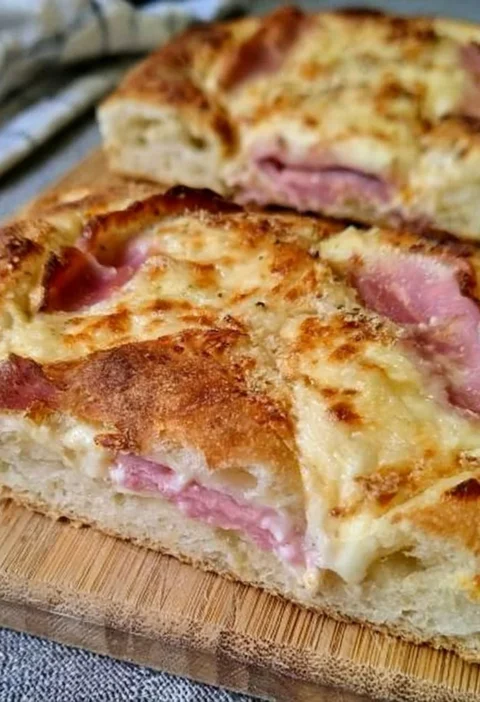 Focaccia soffice con prosciutto cotto e mozzarella, un piatto gustoso e invitante.