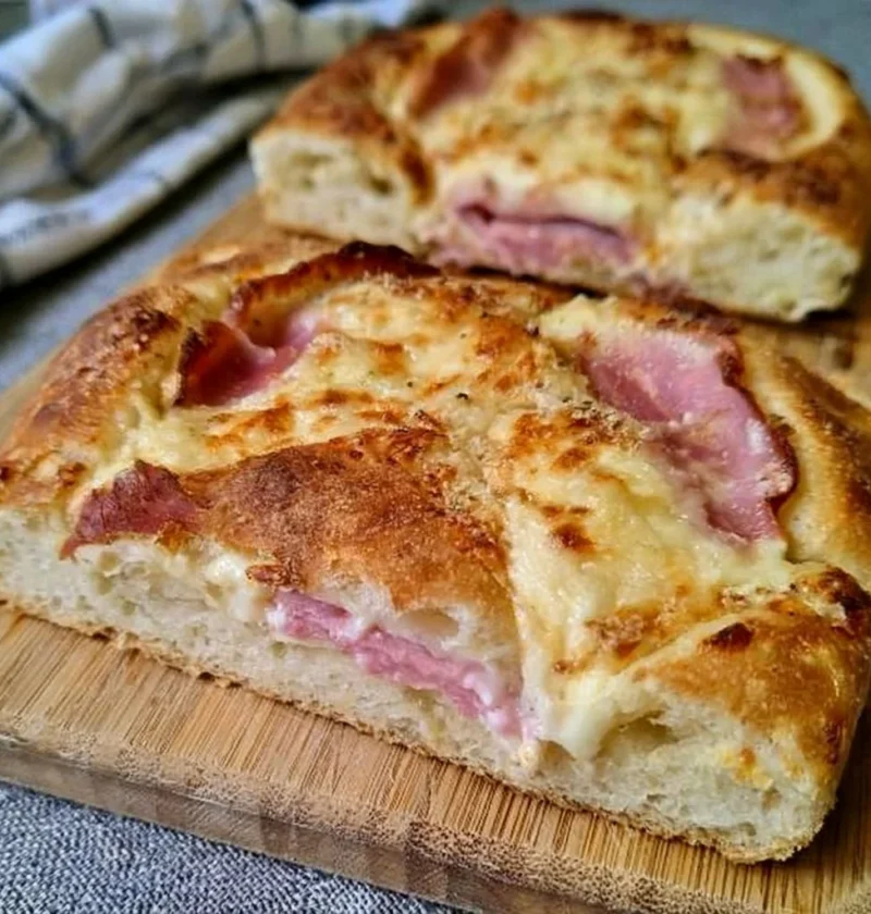 Focaccia soffice con prosciutto cotto e mozzarella, un piatto gustoso e invitante.