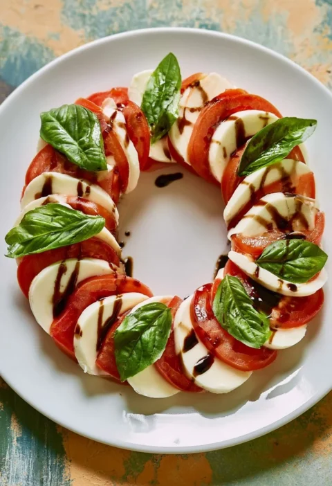 Insalata Caprese con pomodori freschi, mozzarella e basilico su un piatto.