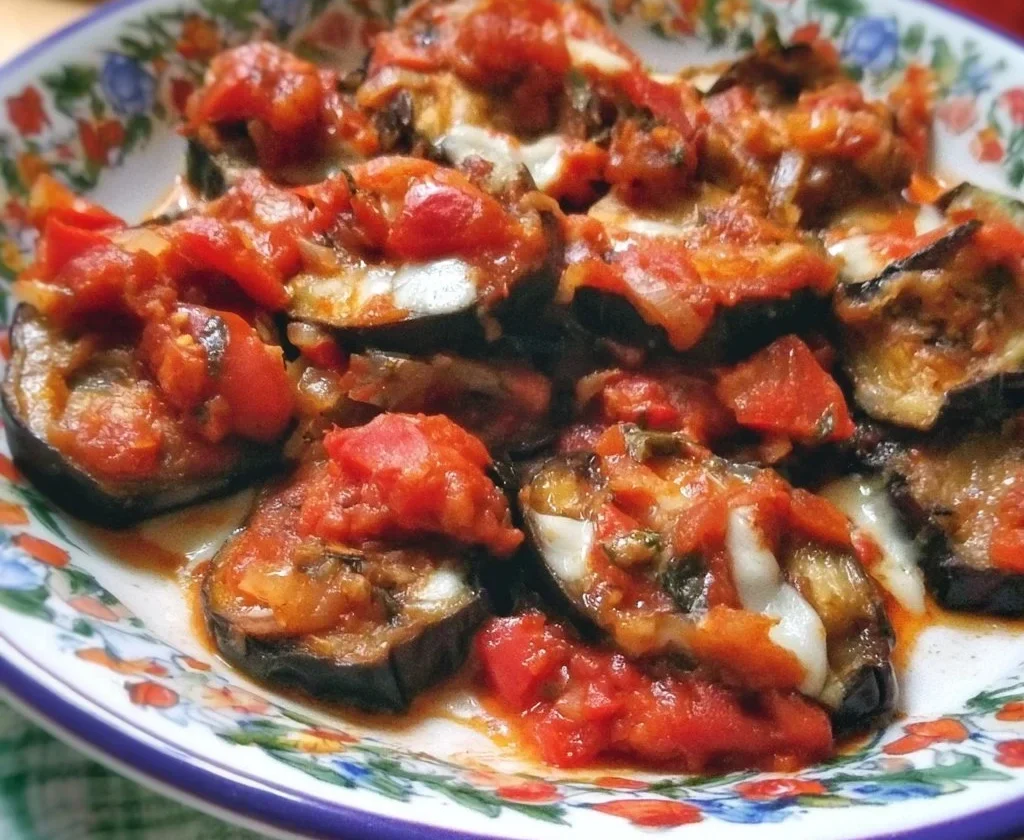 Melanzane alla Pizzaiola servite in un piatto con pomodoro e spezie.