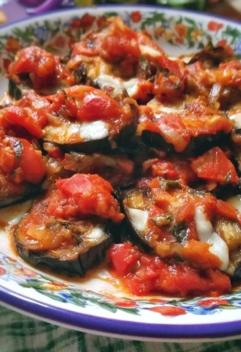 Melanzane alla Pizzaiola servite in un piatto con pomodoro e spezie.