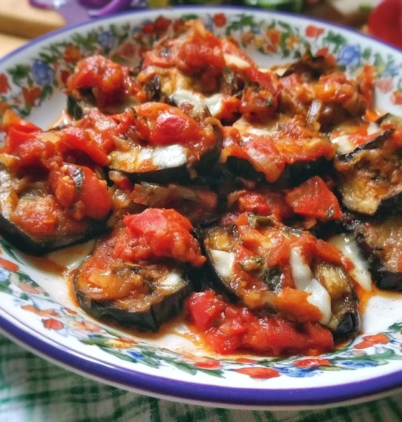 Melanzane alla Pizzaiola servite in un piatto con pomodoro e spezie.