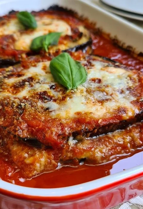Deliziosa Parmigiana di Melanzane in un piatto rustico italiano.