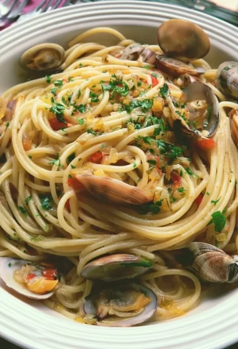 Piatto di spaghetti alle vongole con frutti di mare freschi e prezzemolo