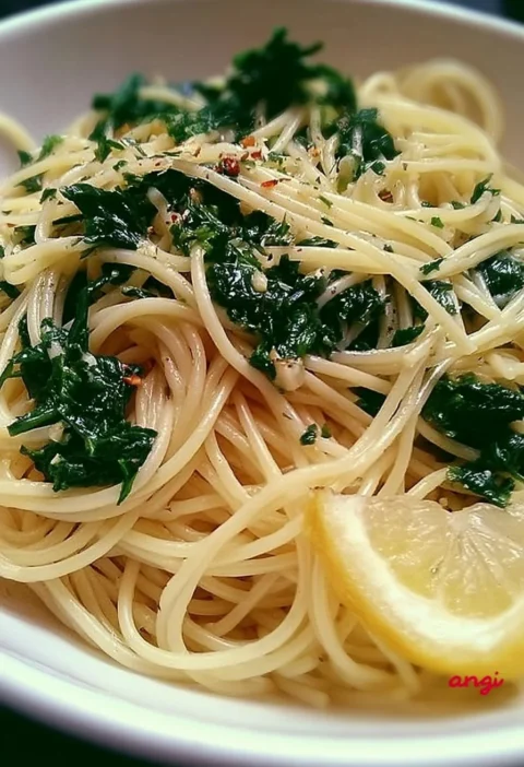 Piatto di spaghetti con aglio e spinaci freschi, un delizioso piatto italiano.
