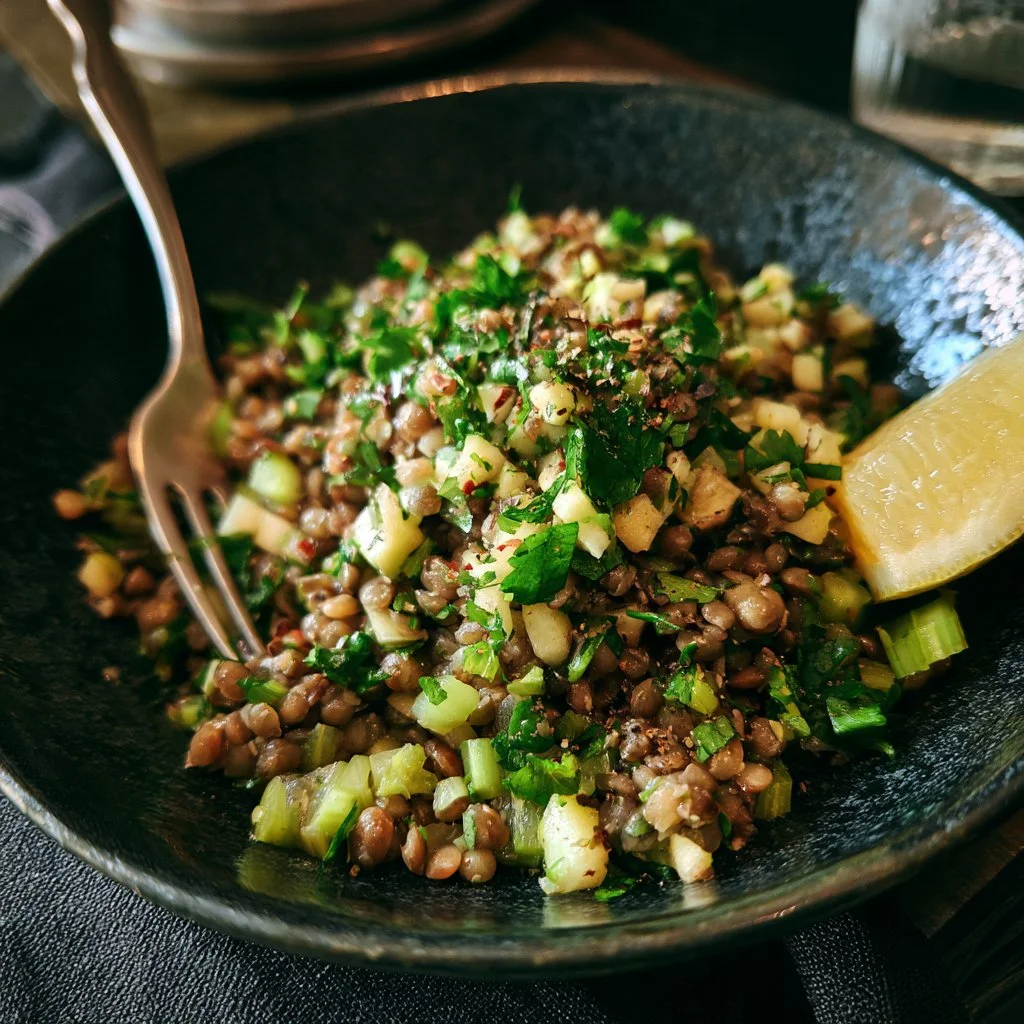 Insalata di lenticchie, mela e sedano pronta da servire in un piatto colorato.
