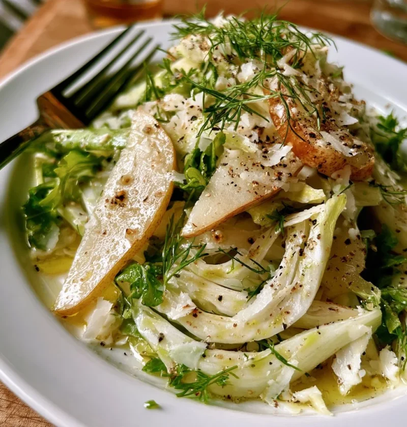 Insalata di pere, finocchi e parmigiano servita in un piatto elegante