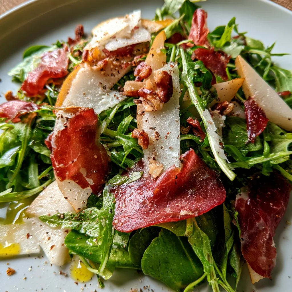 Insalata di rucola con pere, bresaola e grana su un piatto elegante