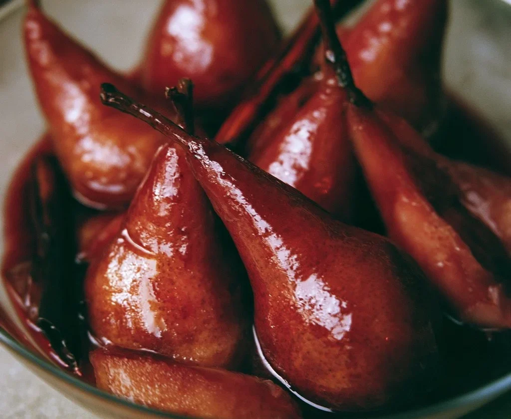 Pere cotte al vino rosso con spezie servite in un piatto