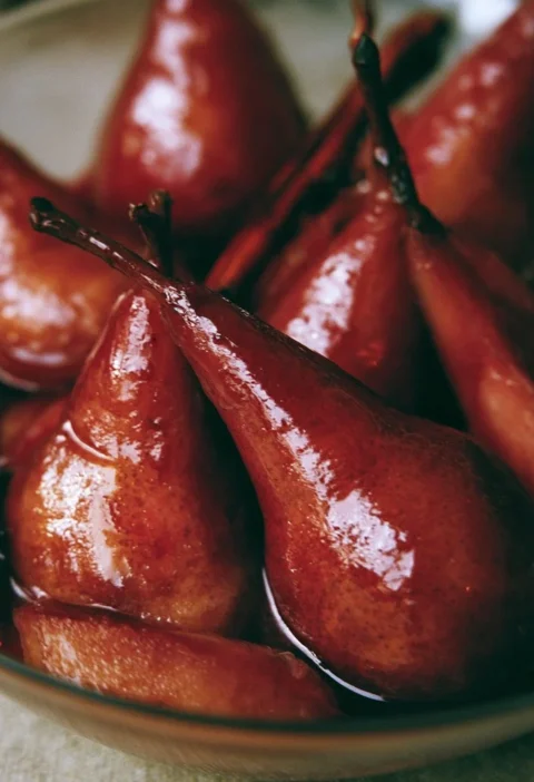 Pere cotte al vino rosso con spezie servite in un piatto