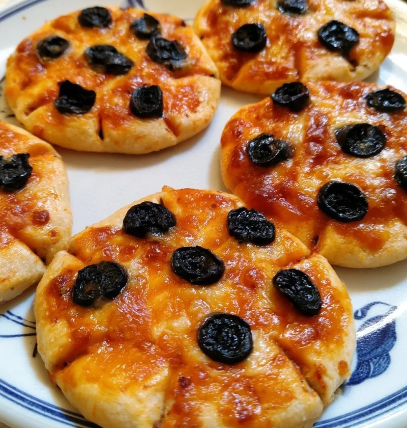 Pizzette ragno con olive nere, un appetitoso spuntino italiano.