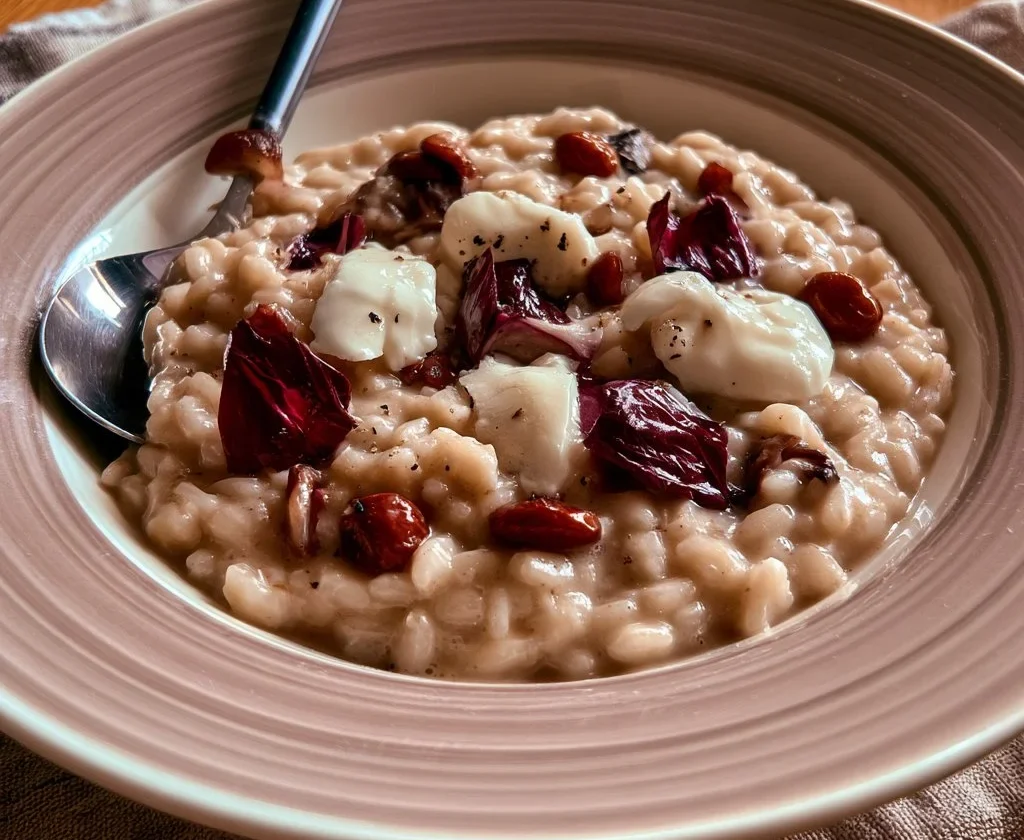 Risotto al radicchio e scamorza servito in un piatto elegante.